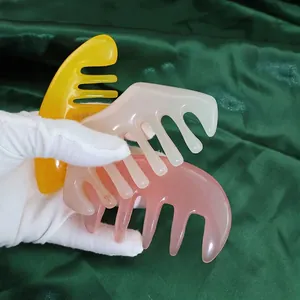 Three-piece set of wide-tooth meridian massage combs in yellow, cream, and pink resin colors