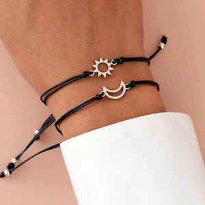 Detail of adjustable black woven sun and moon bracelets worn by two people