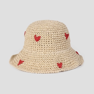 Close-up of crochet sun hat featuring red heart embroidery and breathable straw texture