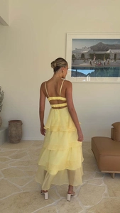 Detail of light yellow backless layered cake dress with crisscross tie-back design