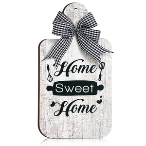 Detail of wooden cutting board wall decor with Home Sweet Home text and plaid bow