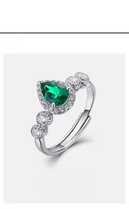 Macro detail of pear-shaped emerald ring with halo diamonds on S925 silver adjustable band