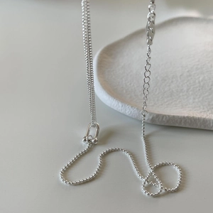 Detail of 925 sterling silver U-shaped buckle necklace with mixed bead and link chain