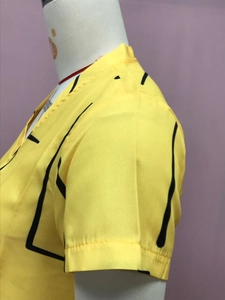 Detail of yellow short-sleeve top with bold black 2D outlines and comic visual style