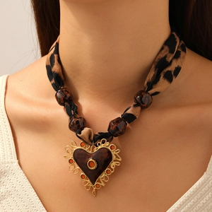 Collier ruban imprimé léopard avec grand pendentif en forme de cœur sur un mannequin