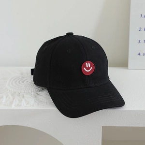Detail of kids baseball cap with a red smiley face embroidery and adjustable strap