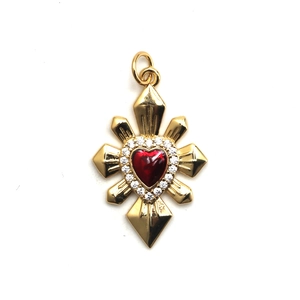 Golden cross pendant with central red heart gemstone and sparkling crystal halo