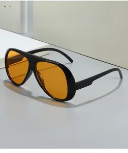 Detail shot of vintage pilot sunglasses with black frames and vibrant orange lenses