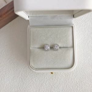 Macro view of square S925 sterling silver earrings with halo zircon in white jewelry box