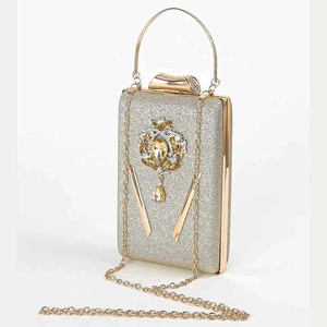 Detail van champagne goud avondtasje met glitterafwerking en strassteentjes