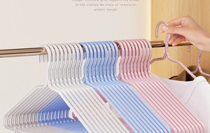 Detail of non-slip seamless plastic hangers with shoulder notches in various colors