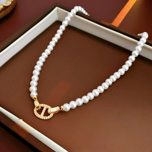 Vue détaillée du collier de perles plaqué or 18k avec fermoir étincelant en forme de D