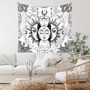 Detailed sun and moon celestial tapestry displayed on white wall in cozy living room setting