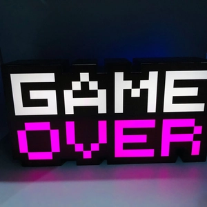 Close-up of GAME OVER pixel art LED lamp with vibrant magenta and white lighting