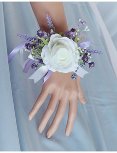 Detailed view of white artificial rose wrist corsage with purple lavender and silk ribbon