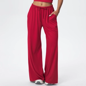 Detail view of red wide leg trousers showing drawstring waist and side pocket texture
