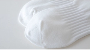 Close-up of white cotton sports socks with fine rib texture and reinforced toe stitching