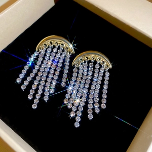 Gros plan détaillé de boucles d'oreilles lune dorées avec pompons en diamants brillants