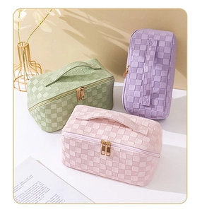 Detailed close-up of three checkered cosmetic bags with zippers and handles