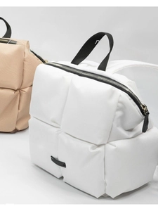 Détail de sacs à dos stylés en patchwork blanc et kaki avec fermeture éclair noire