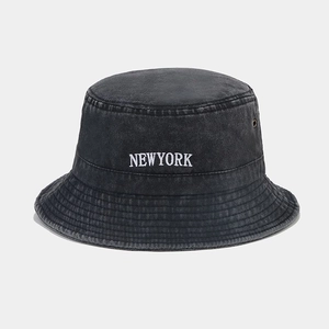 Detail of washed cotton bucket hat with New York embroidery and metal ventilation eyelet
