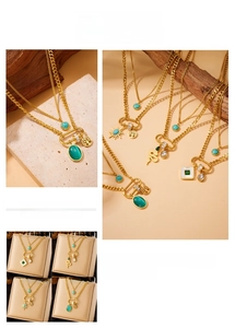 Detail of layered gold snake and tree of life pendants with turquoise and zirconia gems