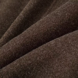 Gros plan sur un tissu en laine marron foncé montrant la texture douce et les fibres