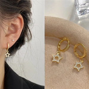 Star dangle earrings in gold finish with micro-paved zircons and hoop buckle design