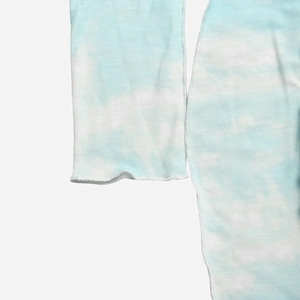 Detail von blau-weißem Tie-Dye-Strickstoff mit Rollsaum-Manschette und sichtbaren Nähten