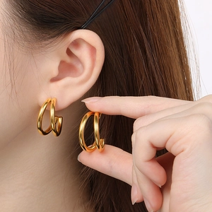 Detailed view of gold plated double C-shaped hoop earrings worn to show style and scale