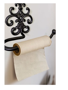 Macro detail of vintage cast iron toilet roll holder featuring elegant fleur-de-lis pattern
