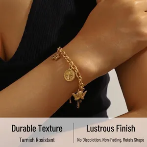 Detailed shot of a gold-plated chunky chain bracelet with angel and cross charms