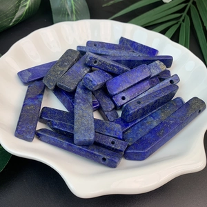 Macro view of long natural blue lapis lazuli pendants with pre-drilled holes for DIY