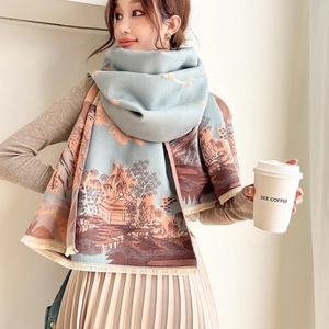 Detail of blue-green cashmere-like scarf showing orange landscape print and fringe edges
