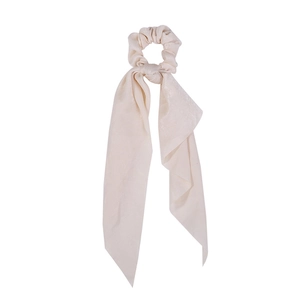 Detailed close-up of a soft beige satin hair scrunchie with long elegant ribbon streamers