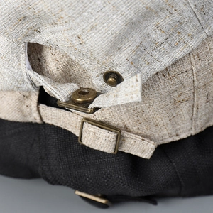 Détail macro de la boucle en laiton réglable et du bouton-pression sur la casquette
