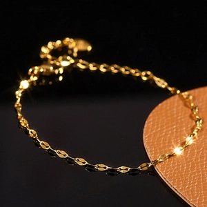 Elegant gold thin wave chain bracelet with adjustable lobster clasp on a dark background