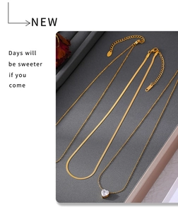 Detailed view of layered gold heart zircon necklace with flat snake and cable chains