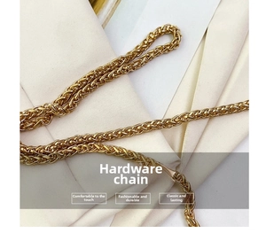 Close-up of golden woven chain hardware detail on stylish handbag with luxury metal texture
