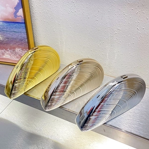 Detailed trio of metallic shell clutches in gold, champagne and silver on display stand