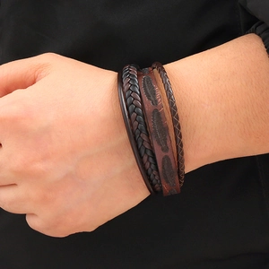 Men's multilayer braided leather bracelet with embossed feather charm on wrist