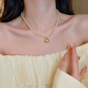 Elegant pearl necklace with golden Chinese fortune bag pendant worn on woman neck