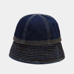 Detailed close-up of dark blue denim bucket hat featuring contrast yellow stitching lines