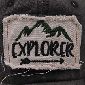 Macro detail of Explorer patch with orange stitching on vintage washed baseball cap