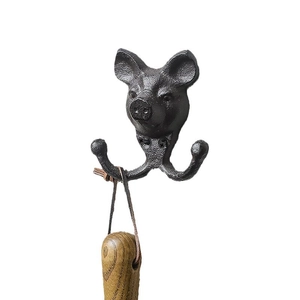 Vintage Wandhaken aus schwarzem Gusseisen in Schweinekopf-Optik auf weißem Grund