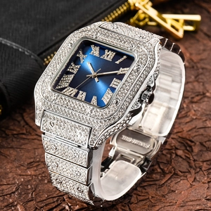Macro shot of silver iced out square watch showing roman numerals and stainless steel clasp