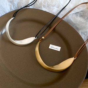 Detailed macro view of minimalist curved metal pendants with a matte brushed finish texture