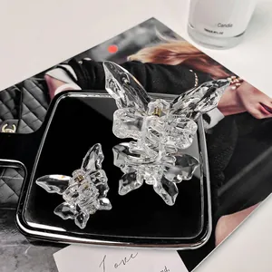 Set of transparent butterfly hair claws in two sizes on a sleek black mirror display
