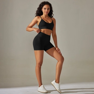 Detail of black seamless high-waist fitness shorts and thin strap sports bra set