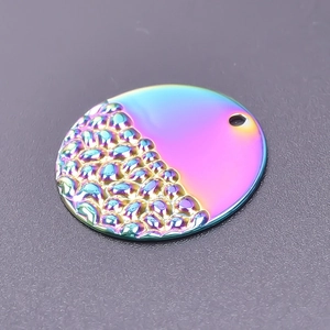 Macro shot of a round textured iridescent pendant with 18k gold plating for DIY necklace